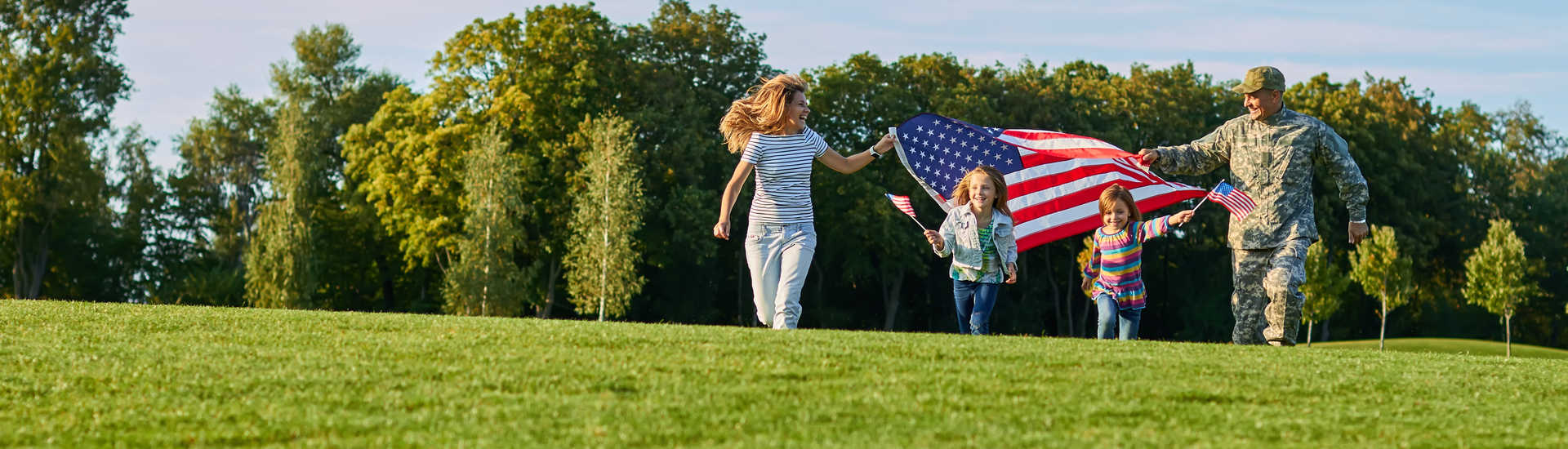 military family with American Flag at a park